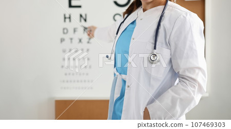 Ophthalmologist standing on background of table measuring vision closeup Ophthalmologist standing on background of table measuring vision closeup 107469303
