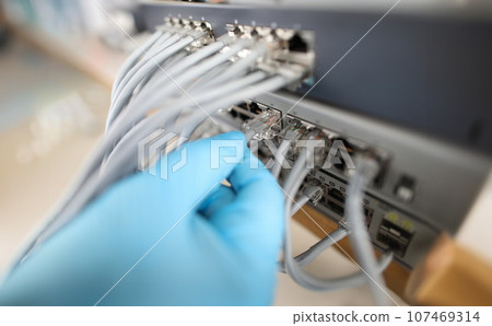 Hand of IT engineer technician with lot of internet network cable in wireless system of server room 107469314