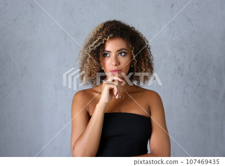 Portrait of a pensive latino woman looks up mysteriously Portrait of a pensive latino woman looks up mysteriously 107469435
