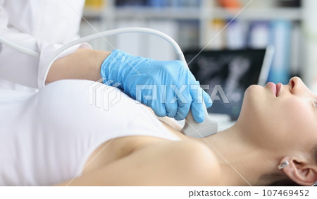 Woman receives ultrasound of thyroid gland from doctor Woman receives ultrasound of thyroid gland from doctor 107469452