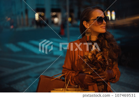 happy trendy female in brown trench coat with shopping bags happy trendy female in brown trench coat with shopping bags 107469531