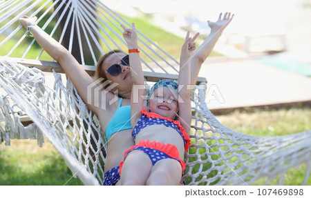Loving family mom and daughter spend time together in summer hammock 107469898