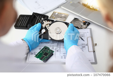Technician repairs computer hard drive from motherboard 107470066
