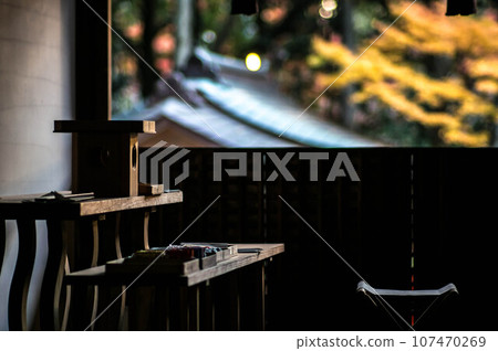 Autumn leaves and sacred utensils illuminated by the setting sun at Ujigami Shrine in Kyoto 107470269
