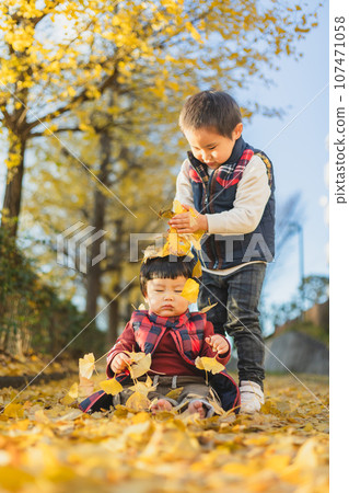 Brother and younger brother playing in the autumn park 107471058