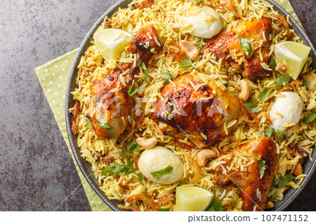 Spicy chicken pulao, polao, biryani, mandi, kacchi with egg closeup on the plate. Horizontal top view Spicy chicken pulao, polao, biryani, mandi, kacchi with egg closeup on the plate. Horizontal top view 107471152