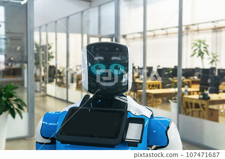 humanoid robot guide expressing emotions against the background of office interior 107471687