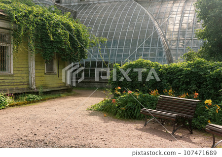 corner of an old botanical garden with a huge vintage greenhouse in the background corner of an old botanical garden with a huge vintage greenhouse in the background 107471689