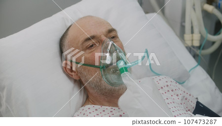 Nurse takes care of sick senior patient in hospital 107473287