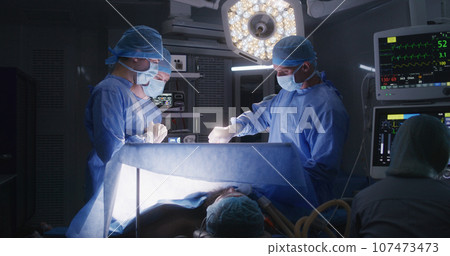 Surgeons operate patient in well-equipped operating room 107473473