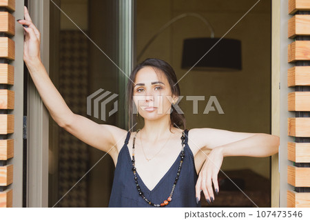 Fashionable woman wearing jumpsuit, posing in stylish boho interior. 107473546