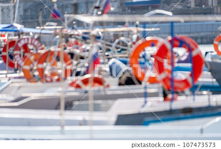 Pier with lifebuoy and boats. Boat for walking. Boat rental. Picture of a boat bow moored to a pier in marina 107473573