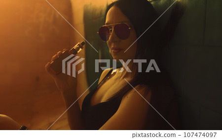 Fashion art portrait of beauty model woman in bright lights with colorful smoke. Smoking girl, Close up of a female inhaling from an electronic cigarette. High quality photo Fashion art portrait of beauty model woman in bright lights with colorful smoke. Smoking girl, Close up of a female inhaling from an electronic cigarette. High quality photo 107474097