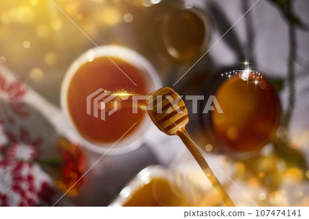 a jar of sweet honey on a table from the garden with apples in a glass  107474141