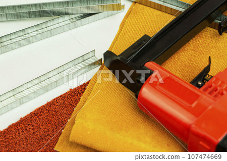concept of furniture production and repair. Stapler and staples, working tool 107474669