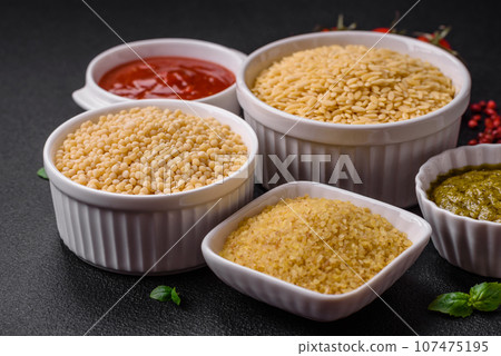 Raw whole grain orzo pasta as an ingredient for a delicious dish Raw whole grain orzo pasta as an ingredient for a delicious dish 107475195