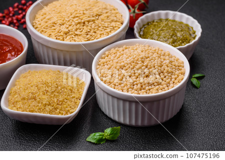 Raw whole grain orzo pasta as an ingredient for a delicious dish Raw whole grain orzo pasta as an ingredient for a delicious dish 107475196