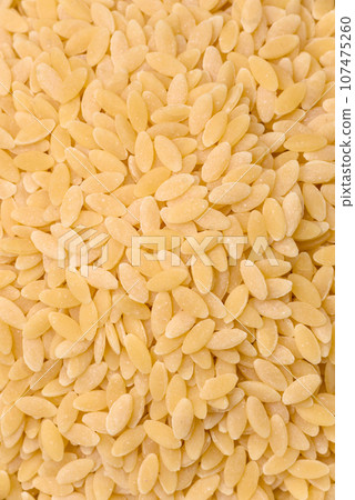 Raw whole grain orzo pasta as an ingredient for a delicious dish Raw whole grain orzo pasta as an ingredient for a delicious dish 107475260