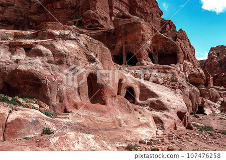 View of the Temples and caves carved into the sandstone rock in the gorge. Petra, Jordan 107476258