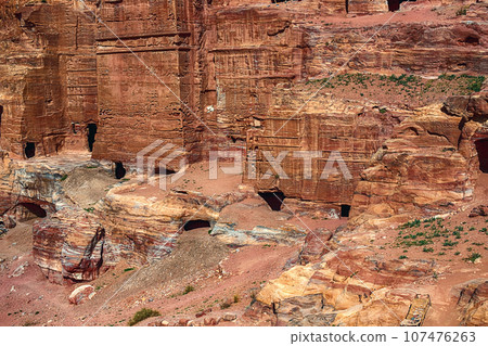 View of the Temples and caves carved into the sandstone rock in the gorge. Petra, Jordan 107476263