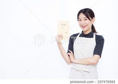 一位 30 多歲的家庭主婦拿著工資袋站在白色背景前 一位 30 多歲的家庭主婦拿著工資袋站在白色背景前 107478988
