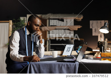 Expert fashion designer overthinking in professional atelier shop workspace, working on handmade stylish business suit. Skilled couturier struggling for ideas for upcoming bespoken collection Expert fashion designer overthinking in professional atelier shop workspace, working on handmade stylish business suit. Skilled couturier struggling for ideas for upcoming bespoken collection 107479512