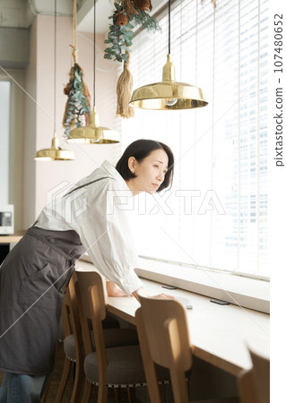 Clerk of a cafe to wipe the table Clerk of a cafe to wipe the table 107480652