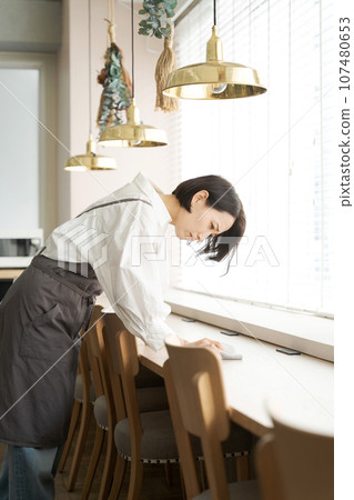 一家咖啡館的職員擦桌子 一家咖啡館的職員擦桌子 107480653