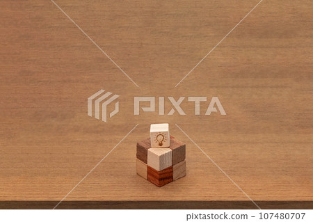 Wood cubes with a light bulb symbol on a combined cube on a wood grain background Wood cubes with a light bulb symbol on a combined cube on a wood grain background 107480707