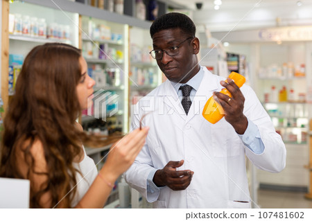 Pharmacist giving woman guidance about haircare 107481602