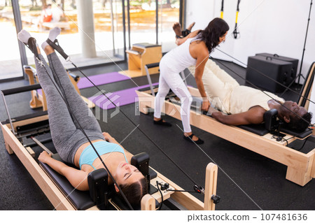 Multethnic group of people training pilates in gym with trainer Multethnic group of people training pilates in gym with trainer 107481636