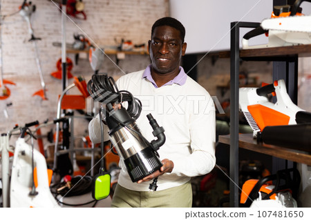Man deciding on best submersible pump in garden equipment shop Man deciding on best submersible pump in garden equipment shop 107481650