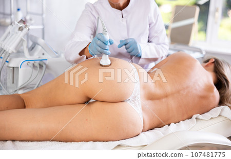 Anti-cellulite hardware massage of buttocks of young woman in beauty clinic 107481775