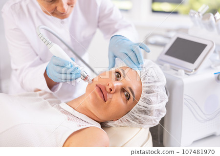 RF lifting and deep hydration for facial skin on young woman in clinic 107481970