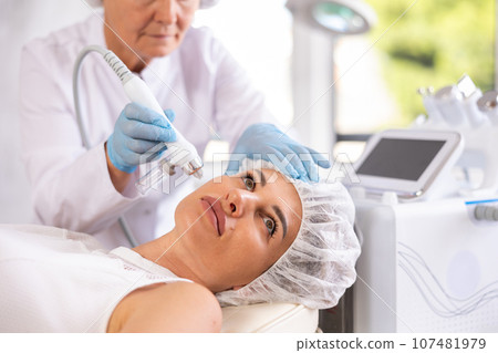 RF lifting and deep hydration for facial skin on young woman in clinic 107481979