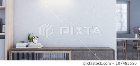 Empty space on a minimal wooden drawer or cabinet against the white wall in a modern living room. Empty space on a minimal wooden drawer or cabinet against the white wall in a modern living room. 107483556
