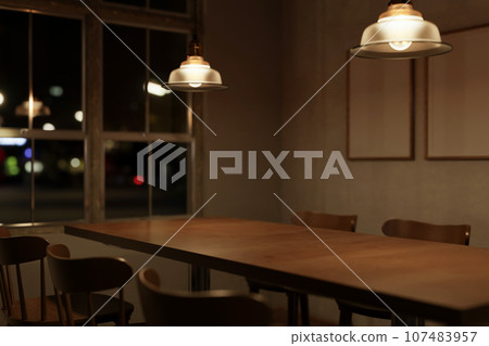 Beautiful vintage wooden dining table with chairs in a minimalist Scandinavian dining room at night. 107483957