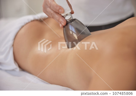 massage machine, lifting body, Cosmetology. Anti-cellulite roller-vacuum massage procedure is available in beauty salon to treat cellulite problem areas. Body care professional equipment is available massage machine, lifting body, Cosmetology. Anti-cellulite roller-vacuum massage procedure is available in beauty salon to treat cellulite problem areas. Body care professional equipment is available 107485806