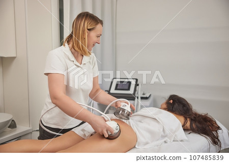 beauty care, modern medical, LPG massage. Body massage with vacuum, problem areas slimming, body care professional equipment, low ph massage procedure, anti-cellulite roller vacuum in medical salon beauty care, modern medical, LPG massage. Body massage with vacuum, problem areas slimming, body care professional equipment, low ph massage procedure, anti-cellulite roller vacuum in medical salon 107485839