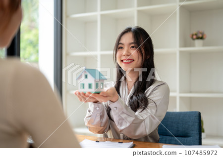 A beautiful Asian female real estate agent having a meeting with a client in her office. 107485972