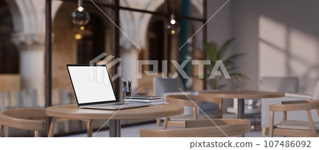 A laptop mockup on a table in a beautiful minimal coffee shop or restaurant. 107486092