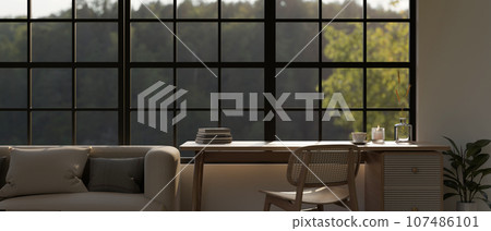 A minimal table with a wooden chair against the window in a beautiful and cozy living room. 107486101