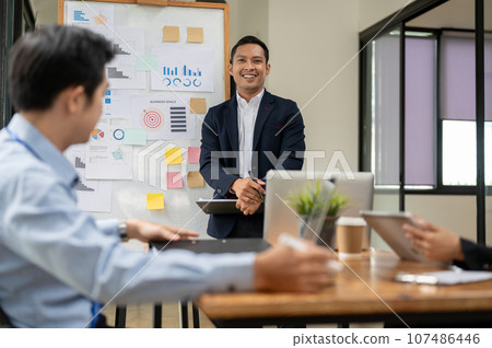 A professional Asian businessman presented his project in front of board members in a meeting 107486446