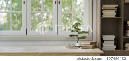 Copy space on a white tabletop against the window and a bookshelf. Copy space on a white tabletop against the window and a bookshelf. 107486480