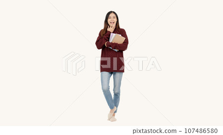 A pretty Asian female college student is holding her books and posing in a cute full-body pose 107486580