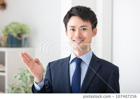 A man wearing a suit and making a hand sign Business A man wearing a suit and making a hand sign Business 107487256