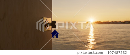 House model and key in house door. Real estate agent offer house, property insurance and security, affordable housing concepts with copyspace on sea sunrise. 3d rendering 107487282