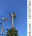 Telephone poles and wires under the blue sky 107487360