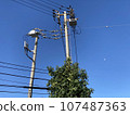 Telephone poles and wires under the blue sky 107487363