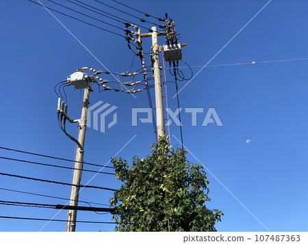 Telephone poles and wires under the blue sky 107487363